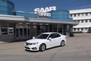 Vit Saab 9-3 Griffin framför huvudentrén till Saabfabriken i Trollhättan
