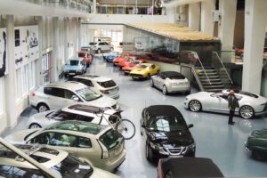 Utställningshallen på Saab Car Museum i Trollhättan med Saab-bilar från olika årtionden under det ljusa taket